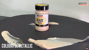 Pentart Glaze paste gold auf einer schwarzen Oberfläche mit einem Spachtel verstrichen