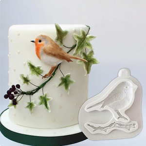 Weiße Silikonform mit Vogelmotiv und eine dekorierte Torte